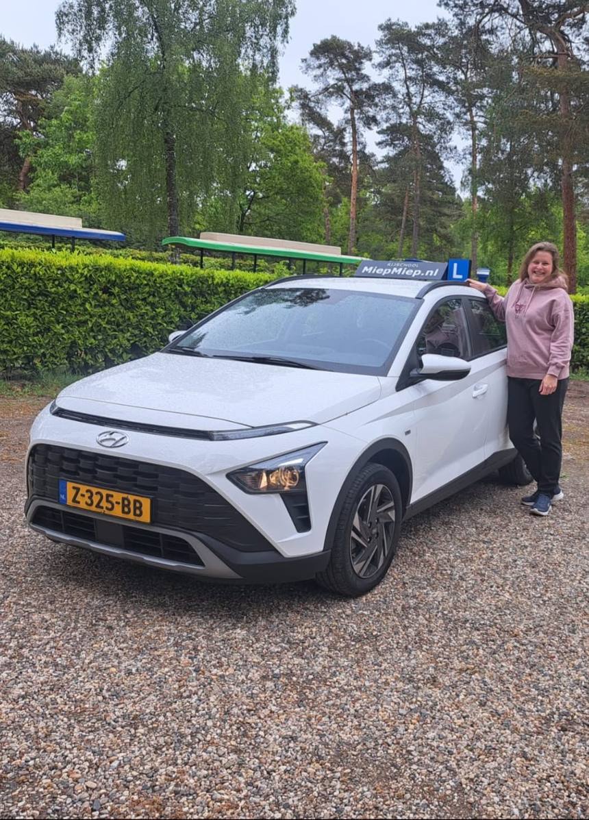 De witte Hyundai Bayon-lesauto van Rijschool Miep Miep, met lesbord op het dak
